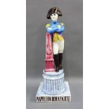19th century pottery figure of Napoleon Bonaparte, modelled standing leaning on an obelisk, on a