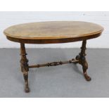 Burr wood table, the oval top on twin supports united by a turned stretcher, 60 x 106cm