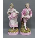 Pair of Continental porcelain male and female figures, each modelled standing , wearing pink and