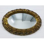 Faux giltwood wall mirror with an oval plate, 92 x 65cm