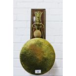 Brass gong and beater on a rectangular wooden wall plaque