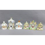 Three Staffordshire cottage pastille burners together with a thatched roof house and a pair of