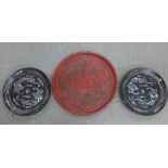 A red chinoiserie charger and a pair of black lacquered and abalone chargers, largest 50cm