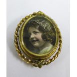 Gilt metal locket brooch / pendant, the glazed panel containing a photographic print of a young