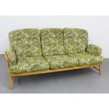 Ercol blonde elm stick back three seater settee, with floral upholstered loose cushions, 85 x 200cm
