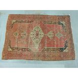 Eastern rug, the worn red field with central medallion and flowerhead border, 300 x 207cm