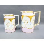 Two continental porcelain jugs, with pink and white ground and gilt pattern, each with a blue