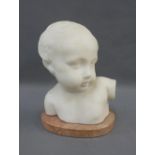 White hardstone head and shoulders bust of a child, on a red marbled hardstone base, 21cm high