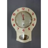 A vintage Smiths eight day wall clock in a cream hard plastic case with red Arabic numerals,
