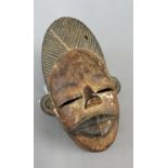 Nigerian Ogoni wooden face mask, the mouth opening to reveal metal teeth, 21.5cm long