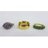 Three 14ct gold rings to include a five stone emerald and diamond ring, a tanzanite ring and a