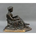 Bronze figure of a female, modelled seated and reading, on a wooden base, 15cm high