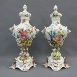 Pair of Nove Italian pottery lidded vases, with handpainted flower pattern and mask heads, on rococo