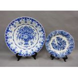 Two Delft blue and white pottery chargers, one with a basket of flowers pattern the other with