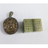 An Eastern white metal locket with Thai style figures and an Eastern white metal box, the cover with
