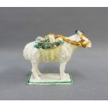 Prattware figure of a Ram with two baskets, on a rectangular green lined base, 11cm high