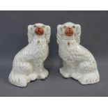 A pair of Staffordshire white glazed chimney spaniels, 24cm high (2)