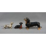 Beswick black and tan dachshund figure together with a smaller Beswick dachshund and a white metal