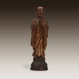 A Chinese gilt wood figural carving of a standing lohan, 19th century or earlier