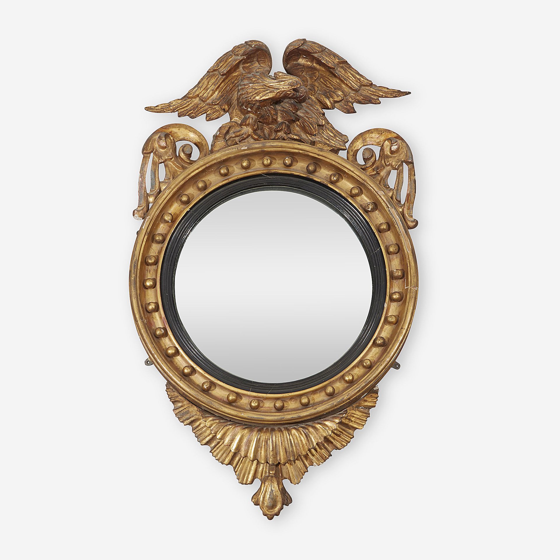 A Regency parcel-ebonized giltwood convex mirror, First quarter 19th century