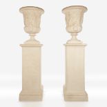 A pair of cast stone campana urns on pedestals, 20th century