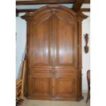 Importante armoire en bois naturel mouluré et sculpté, ouvrant par deux vantaux en [...]