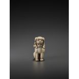 AN IVORY NETSUKE OF A SHISHI STATUE SIGNED TOMOKAZU