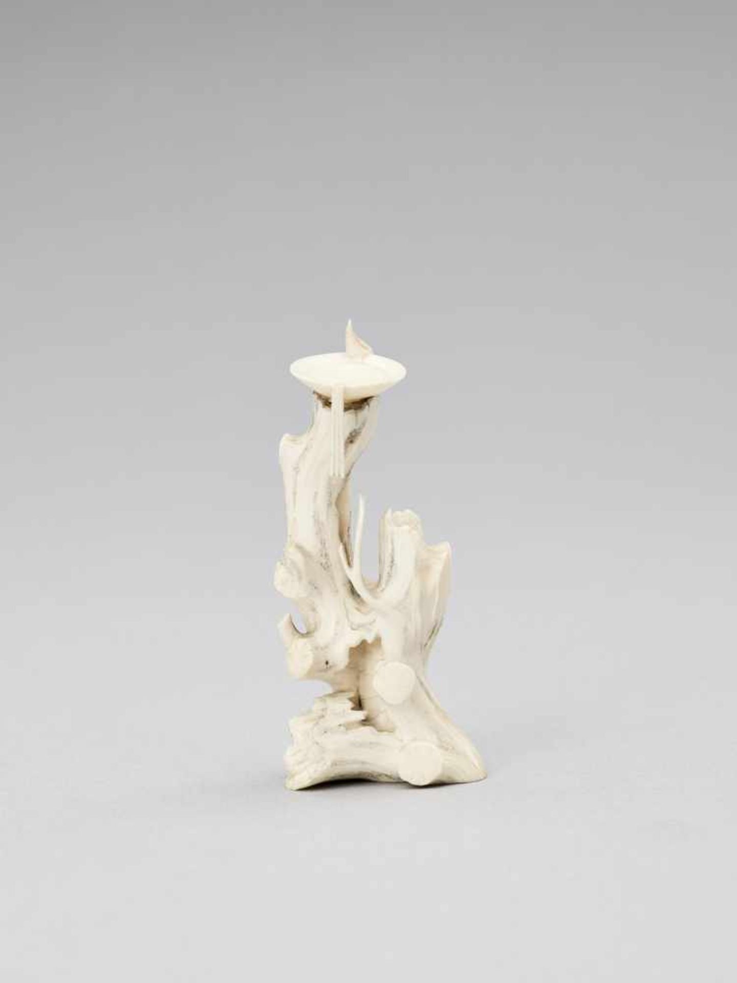 A SMALL IVORY OKIMONO OF AN OLD TREE TRUNK