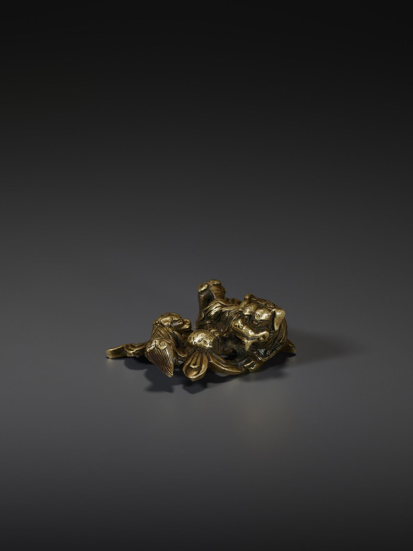 A SHISHI BRONZE SCROLL WEIGHT