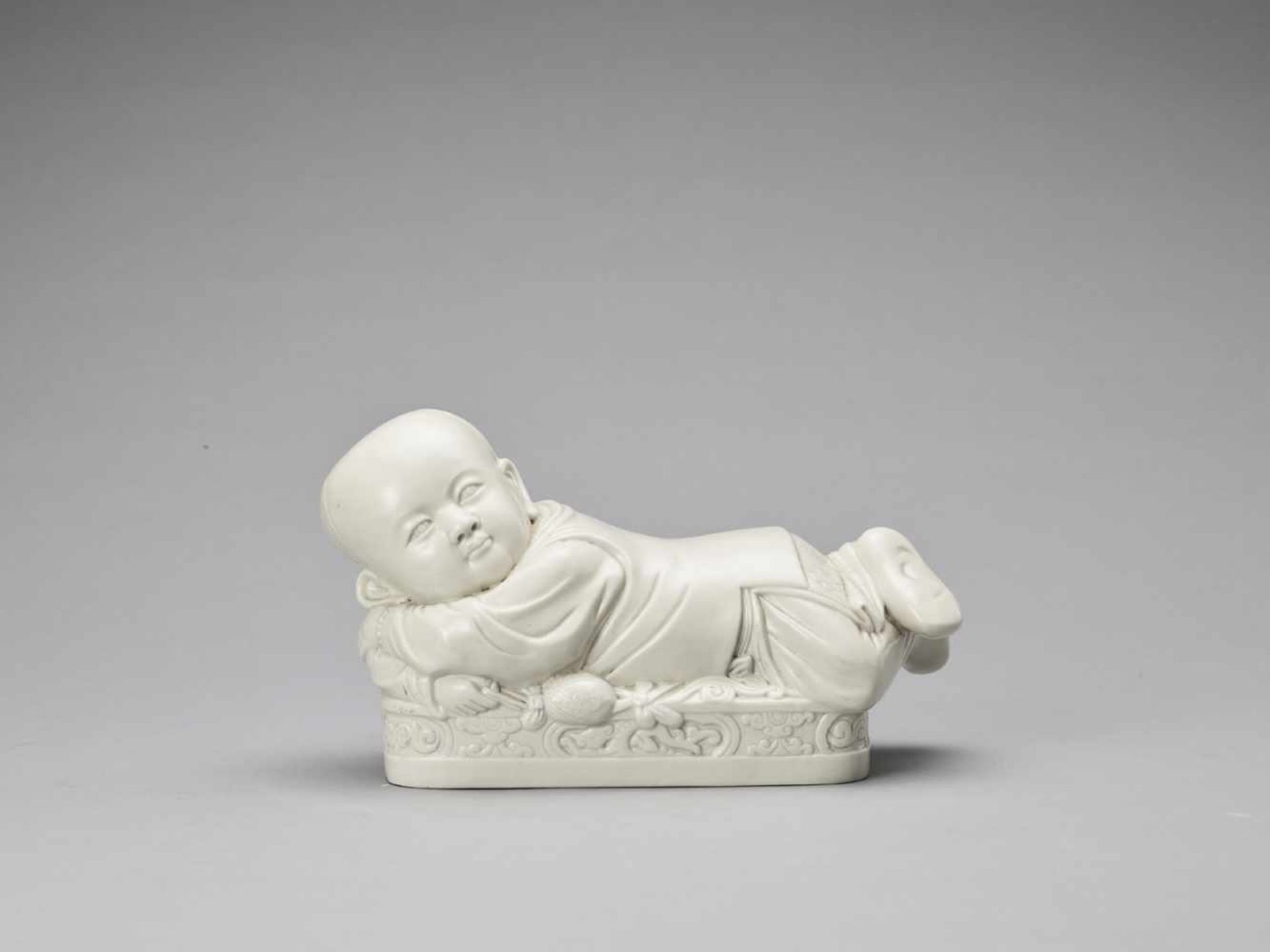 A WHITE GLAZED DEHUA PORCELAIN ‘BOY’ PILLOW, EARLY QING <br