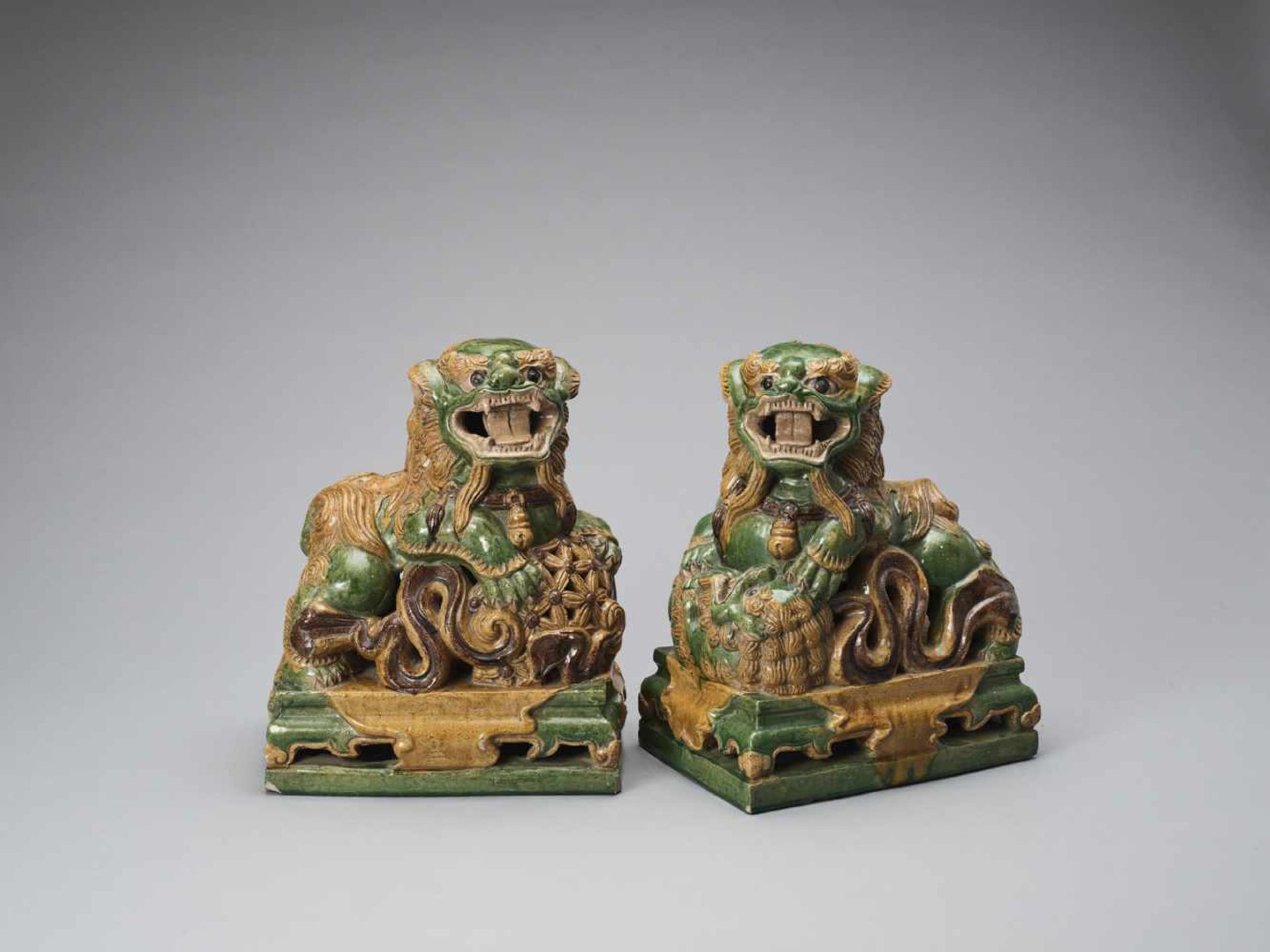 A PAIR OF RETICULATED SANCAI GLAZED POTTERY BUDDHIST LIONS, LATE MING TO EARLIER QING