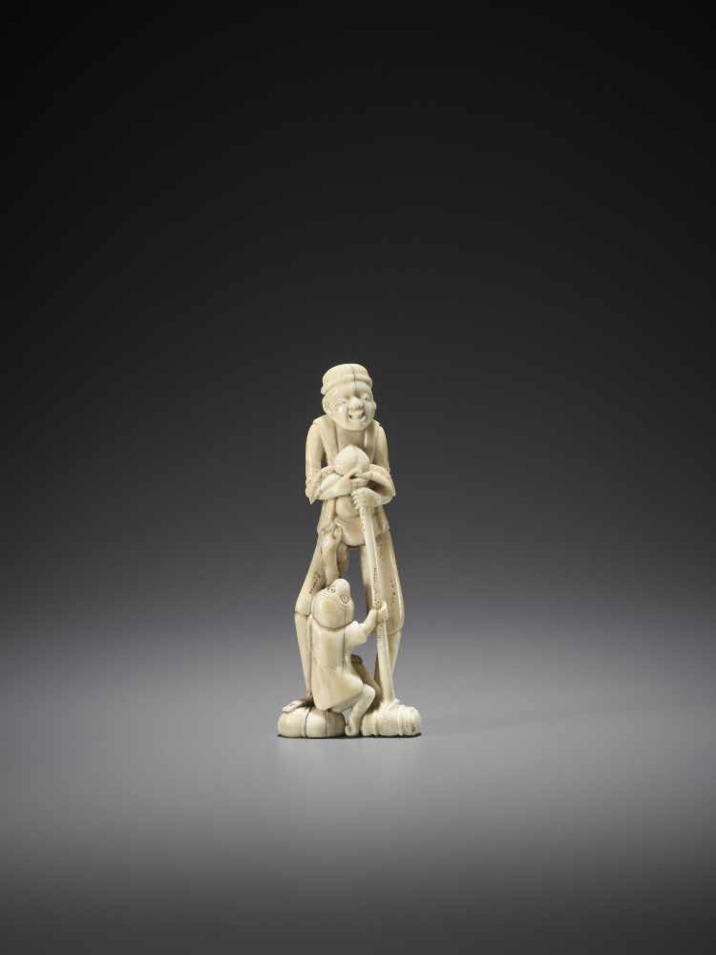 A TALL WALRUS IVORY NETSUKE OF A SARUMAWASHI