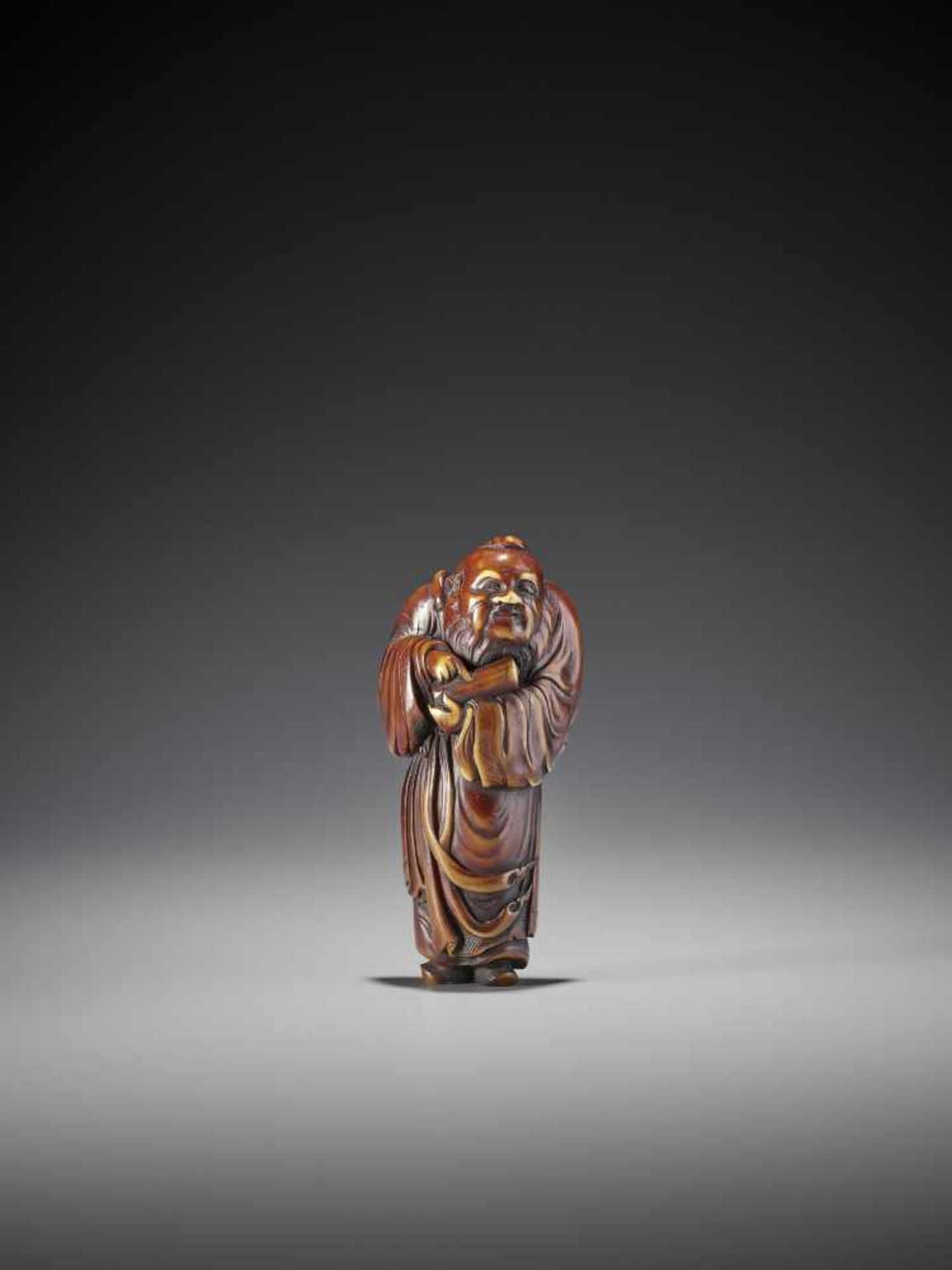 A LARGE STAINED IVORY NETSUKE OF A CHINESE IMMORTAL