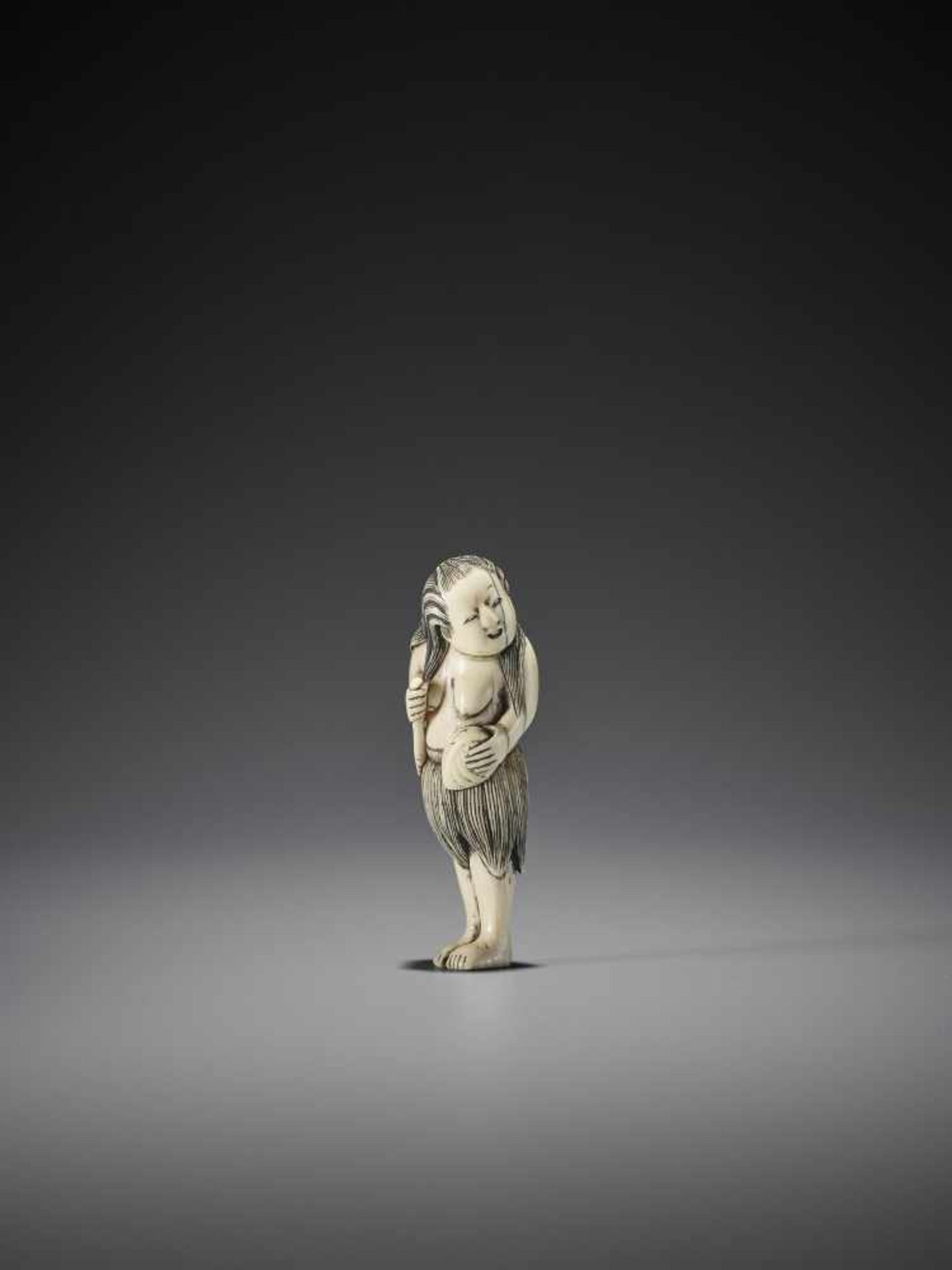 A FINE IVORY NETSUKE OF A STANDING AMA WITH AWABI