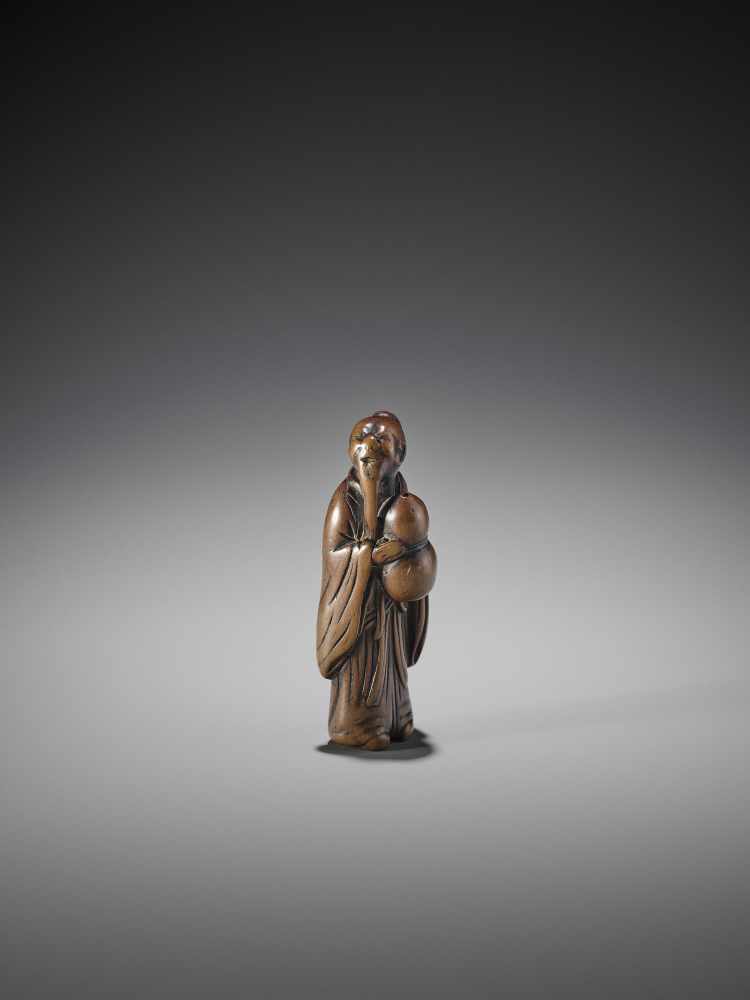 AN EARLY WOOD NETSUKE OF A CHINESE SAGE WITH GOURD