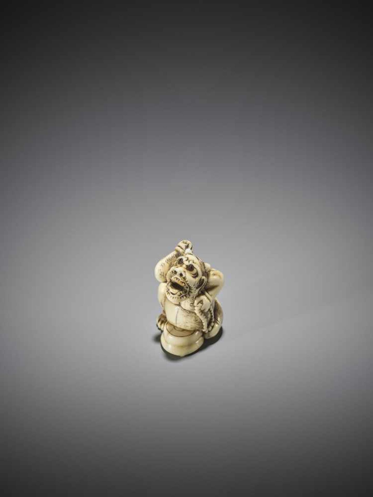 AN IVORY NETSUKE OF A CONVERTED ONI