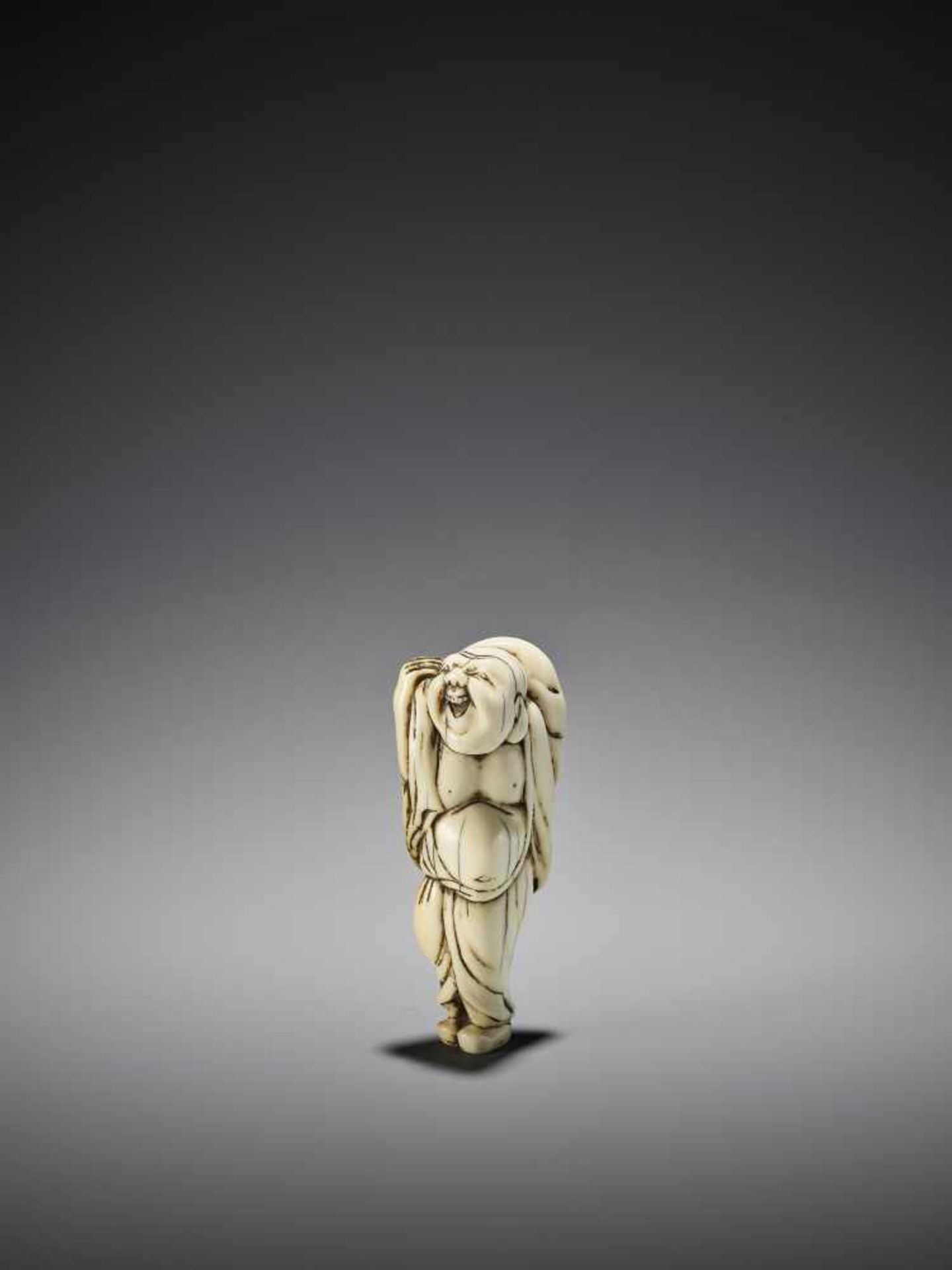 AN IVORY NETSUKE OF HOTEI