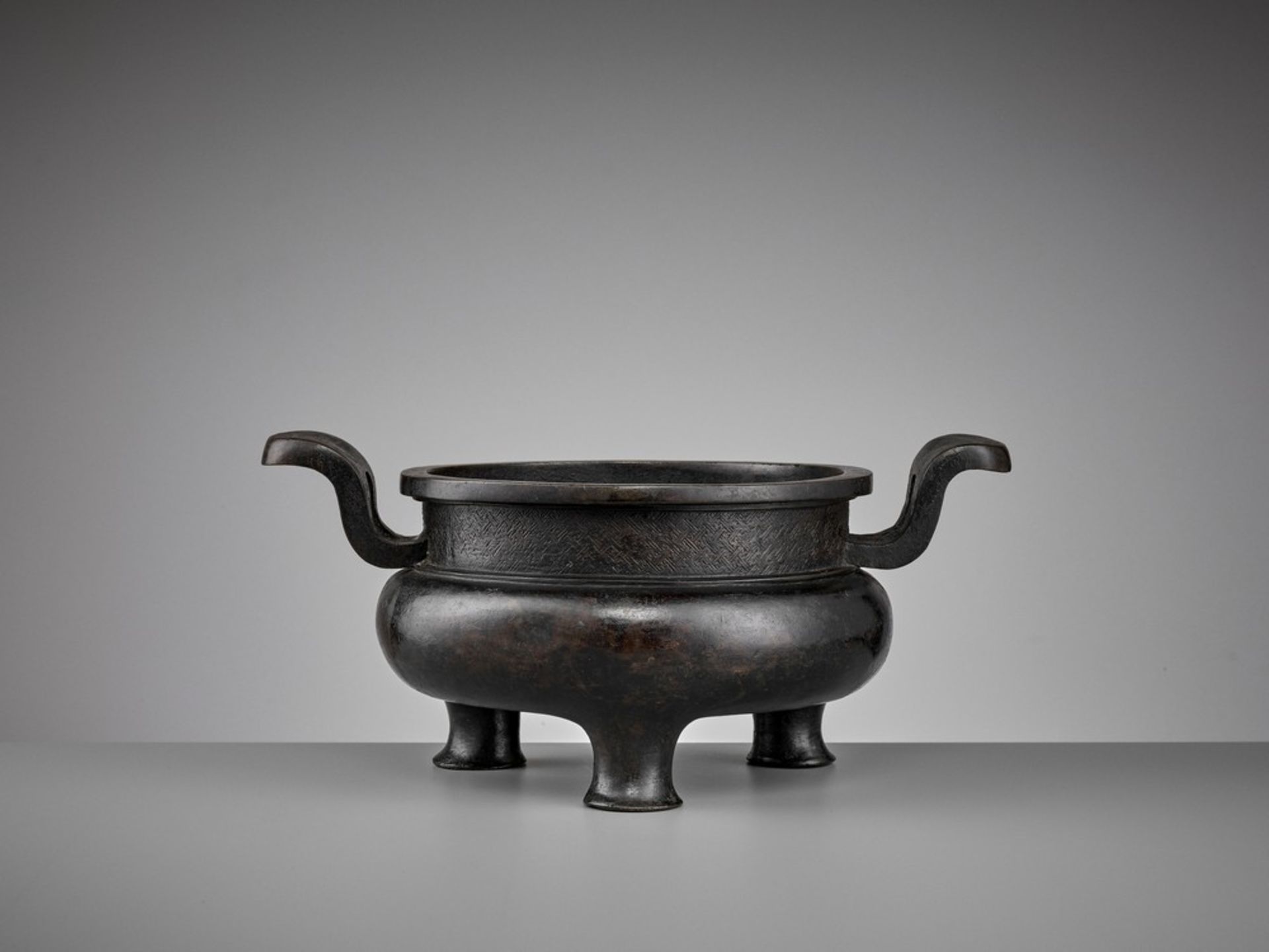 A HEAVILY CAST BRONZE TRIPOD CENSER, YUAN TO MING