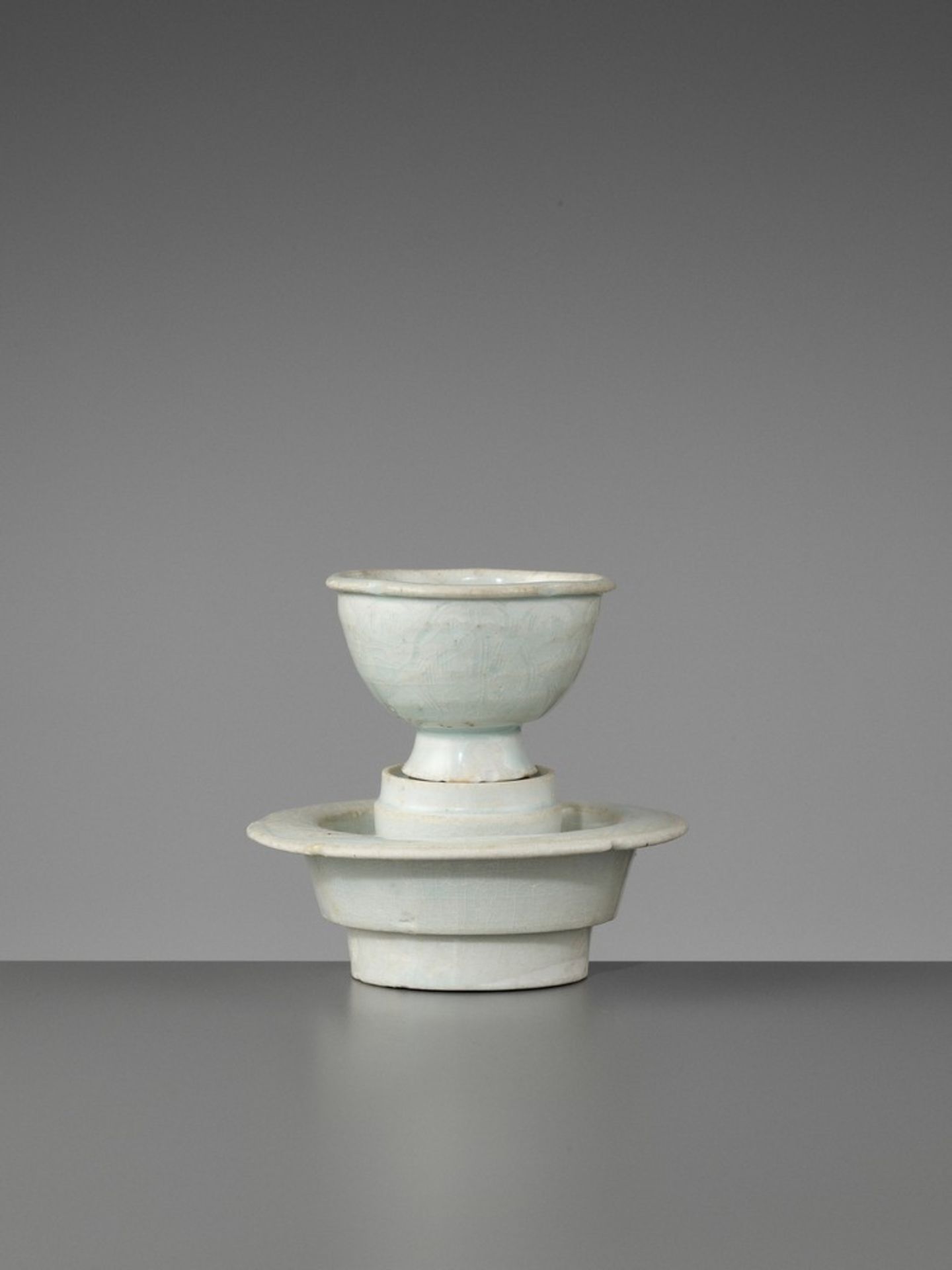 A QINGBAI STEM CUP AND STAND, NORTHERN SONG China, 960-1127. The cup with a lobed everted rim