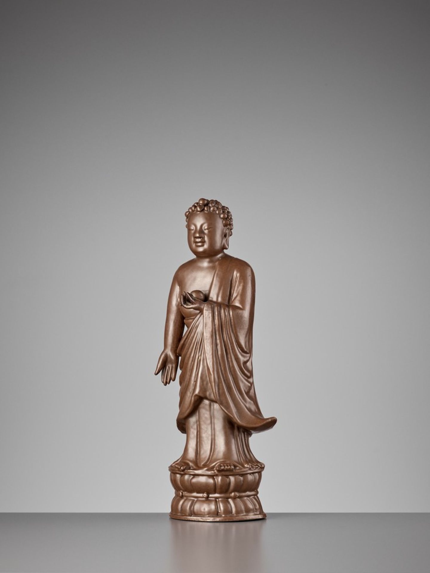 A PERSIMMON GLAZED PORCELAIN STATUE OF BHAISAJYAGURU, QING DYNASTY
