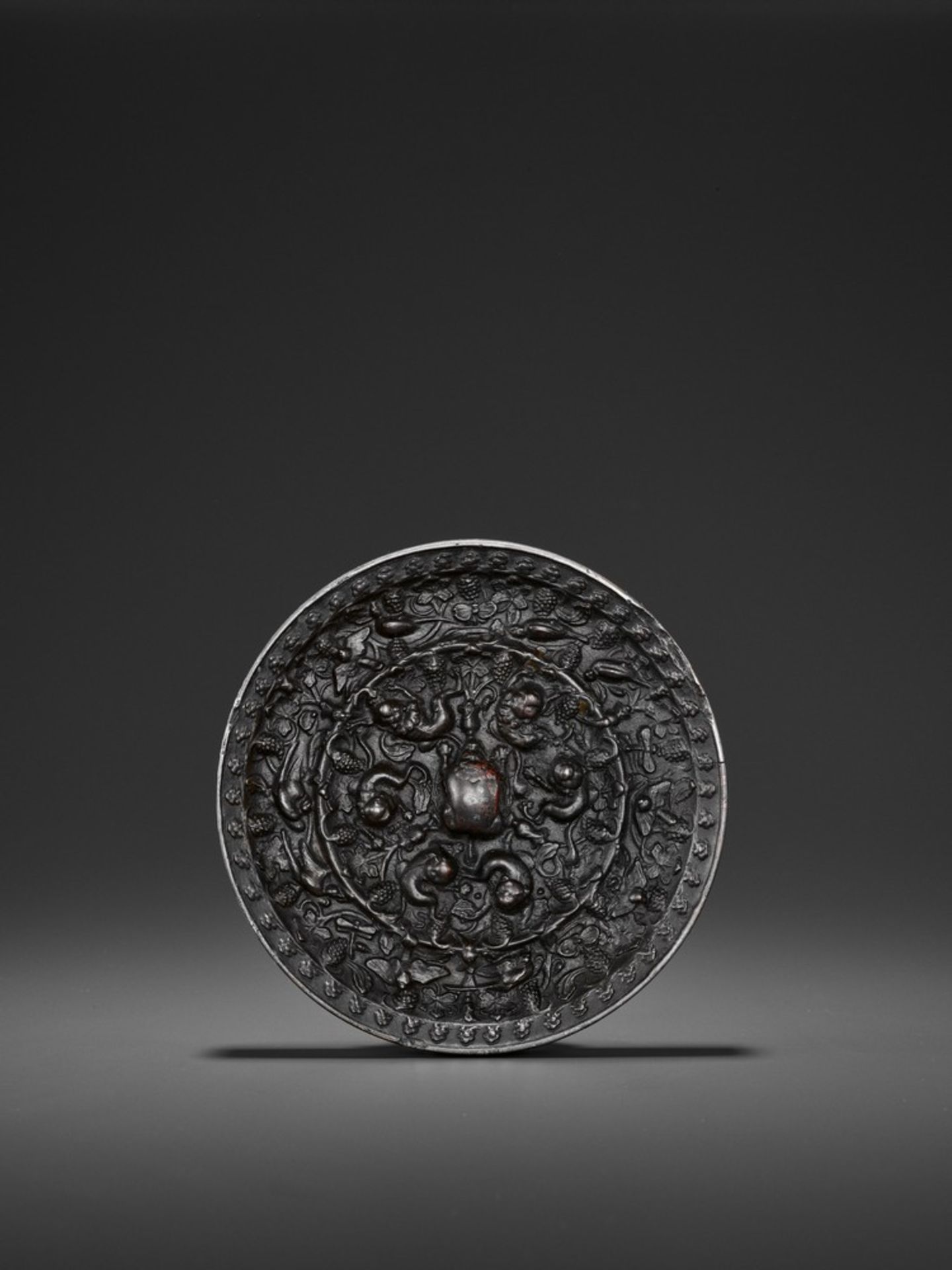 A BRONZE 'LION AND GRAPEVINE' CIRCULAR MIRROR, TANG DYNASTY