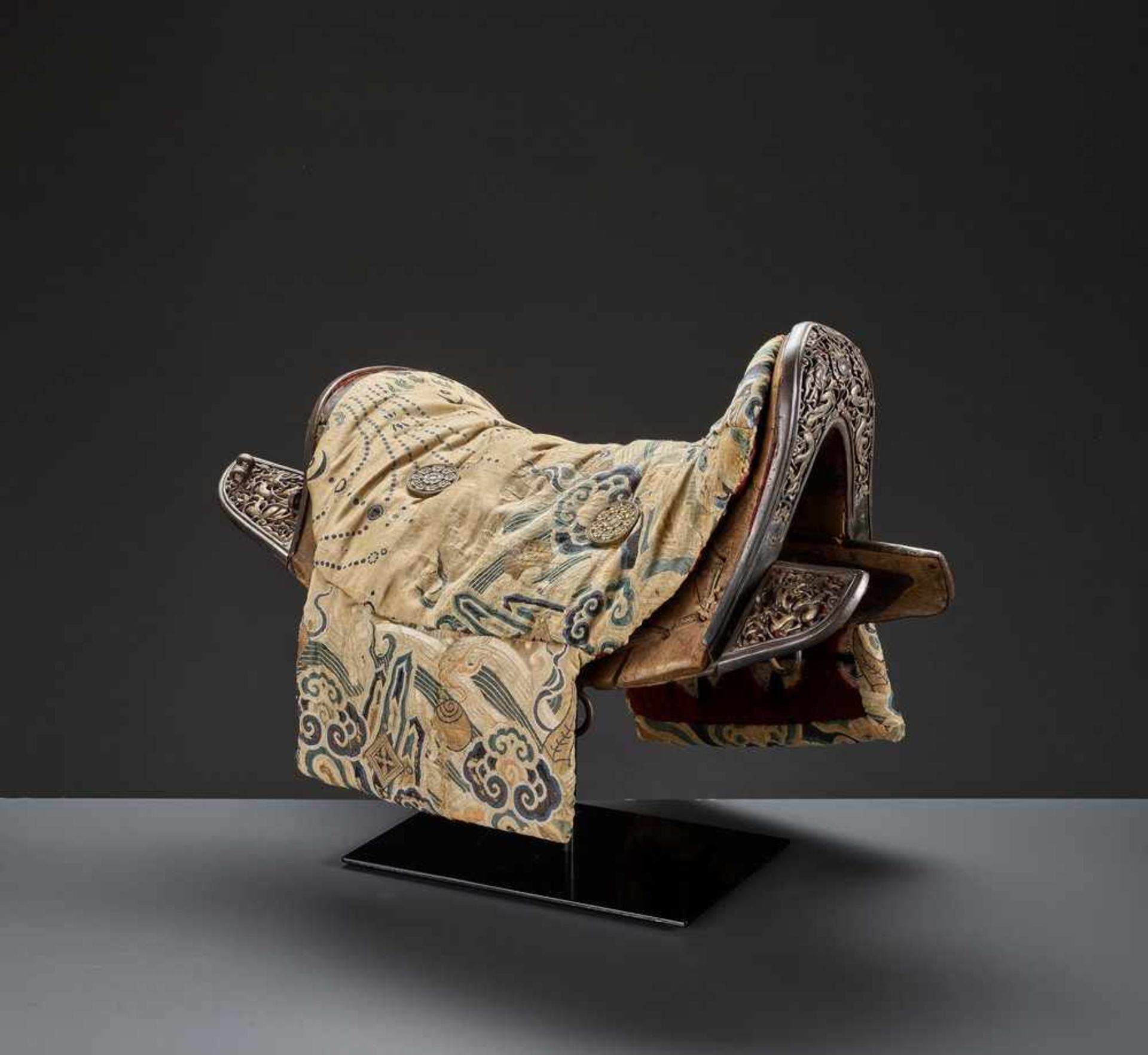 A WOOD SADDLE WITH GILT IRON FITTINGS AND SILK BROCADE COVER, 17TH-18TH CENTURY Sino-Tibetan, late