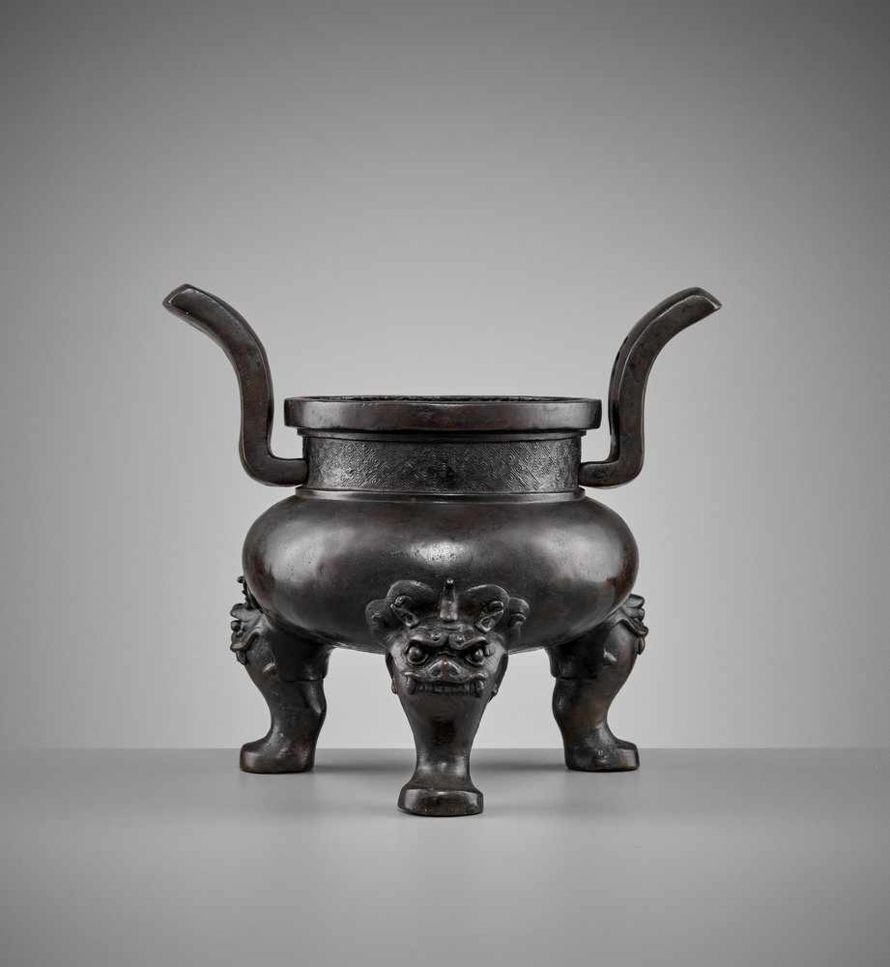 A HEAVILY CAST BRONZE TRIPOD CENSER, MING DYNASTY