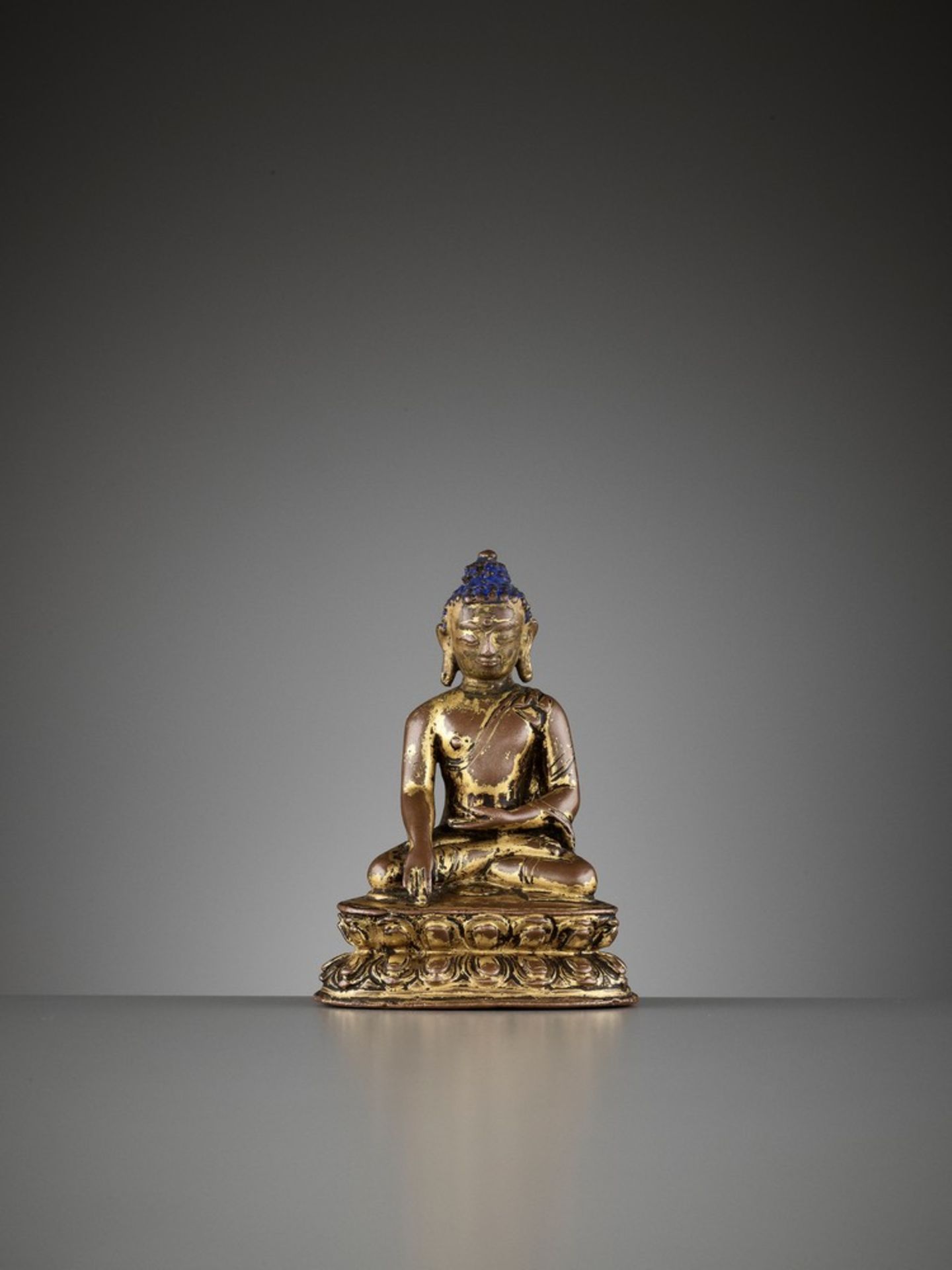 A SMALL GILT COPPER ALLOY FIGURE OF SHAKYAMUNI BUDDHA