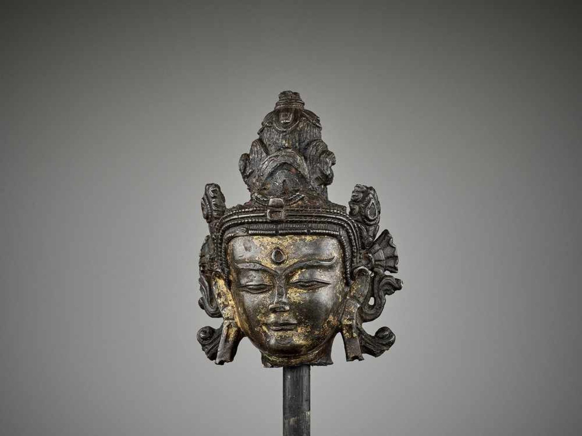 A TIBETAN LACQUER-GILT BRONZE HEAD OF A BODHISATTVA, 14TH-15TH CENTURY