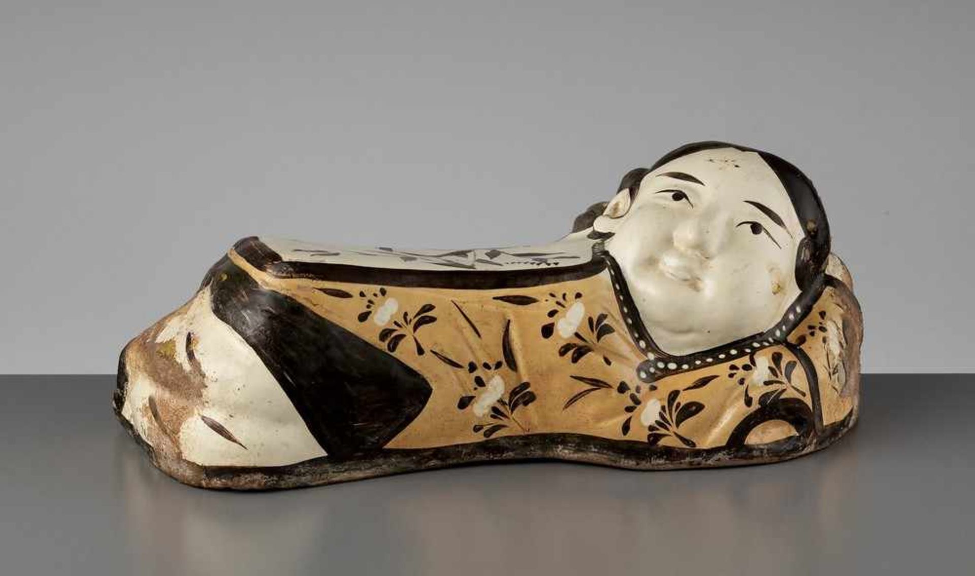 A PAINTED CIZHOU ‘SLEEPING LADY’ PILLOW, JIN DYNASTY China, 1115-1234. Modeled in the form of a