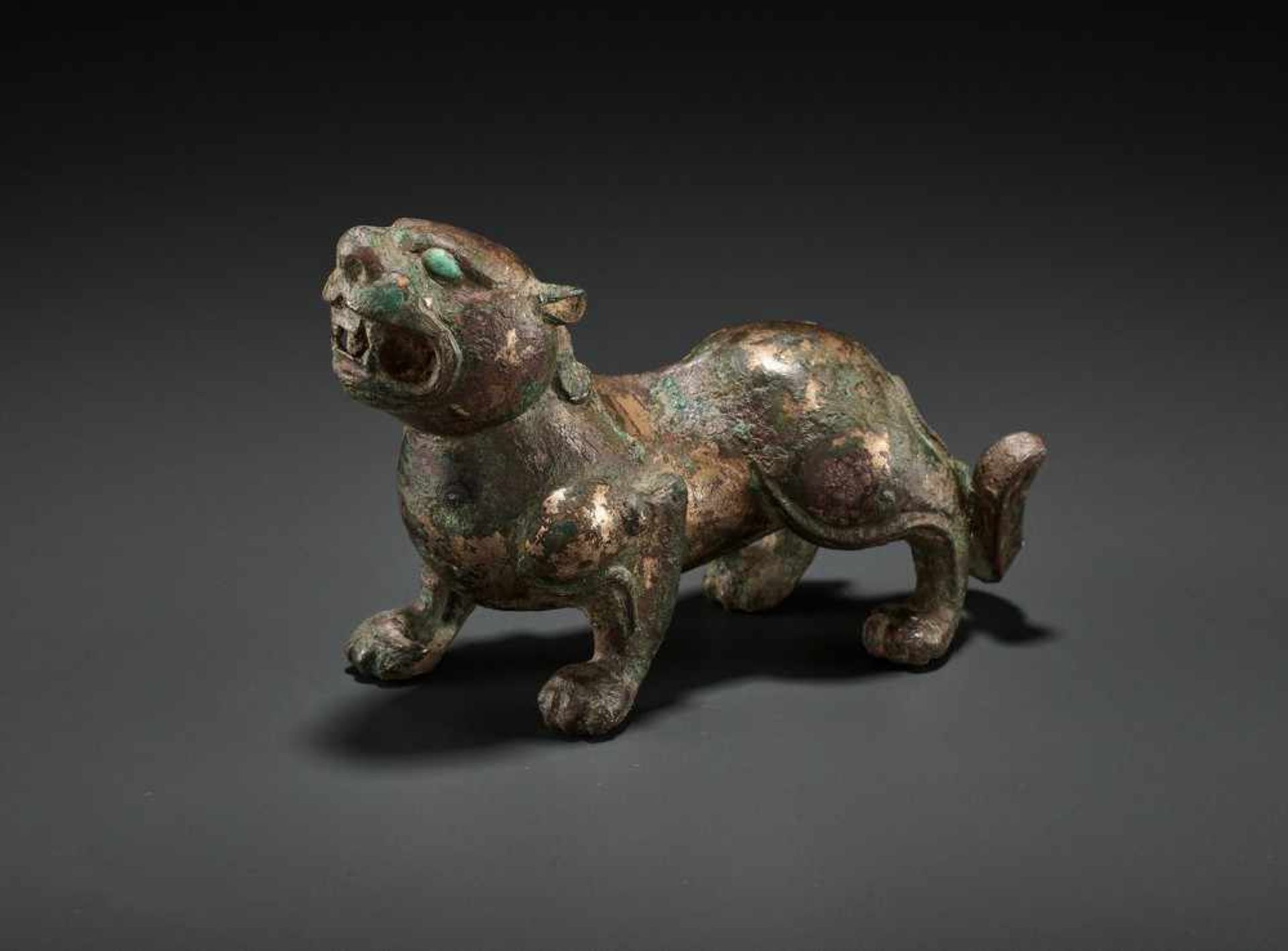 AN INLAID GILT-BRONZE ‘ROARING’ TIGER, WARRING STATES TO WESTERN HAN DYNASTY China, c. 250-200 BC.