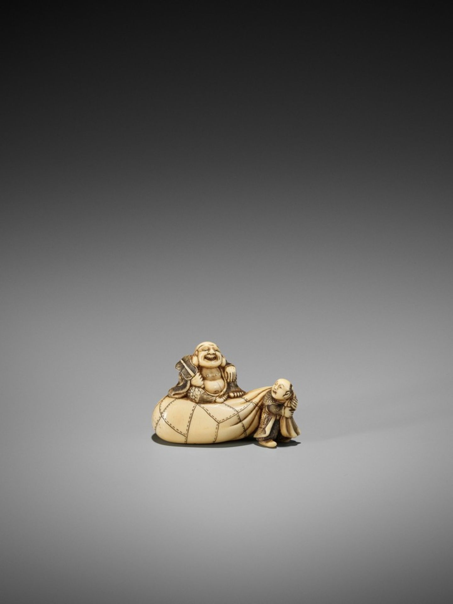 AN IVORY NETSUKE OF HOTEI ON HIS TREASURE BAG BEING PULLED BY A KARAKO UnsignedJapan, Kyoto, first