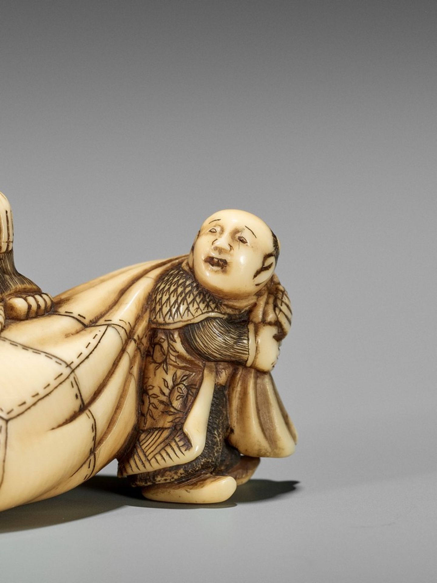 AN IVORY NETSUKE OF HOTEI ON HIS TREASURE BAG BEING PULLED BY A KARAKO UnsignedJapan, Kyoto, first - Bild 9 aus 10