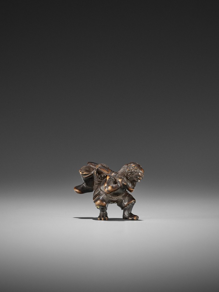 KOGYOKU: A FINE WOOD NETSUKE OF AN ONI STEALING SHOKI’S BELONGINGS By Kogyoku, signed Kogyoku